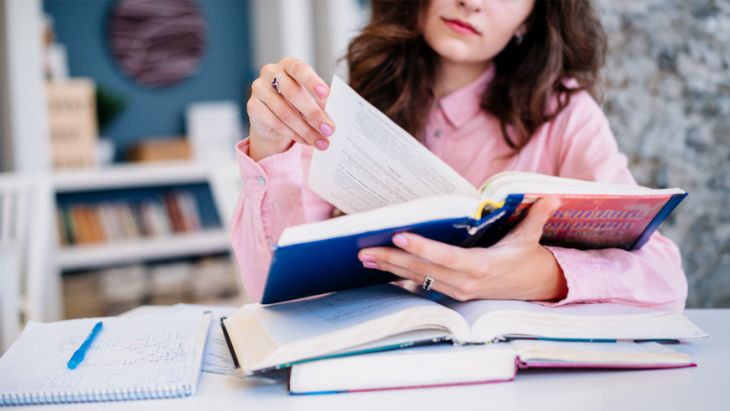 Девушки читает книгу за столом